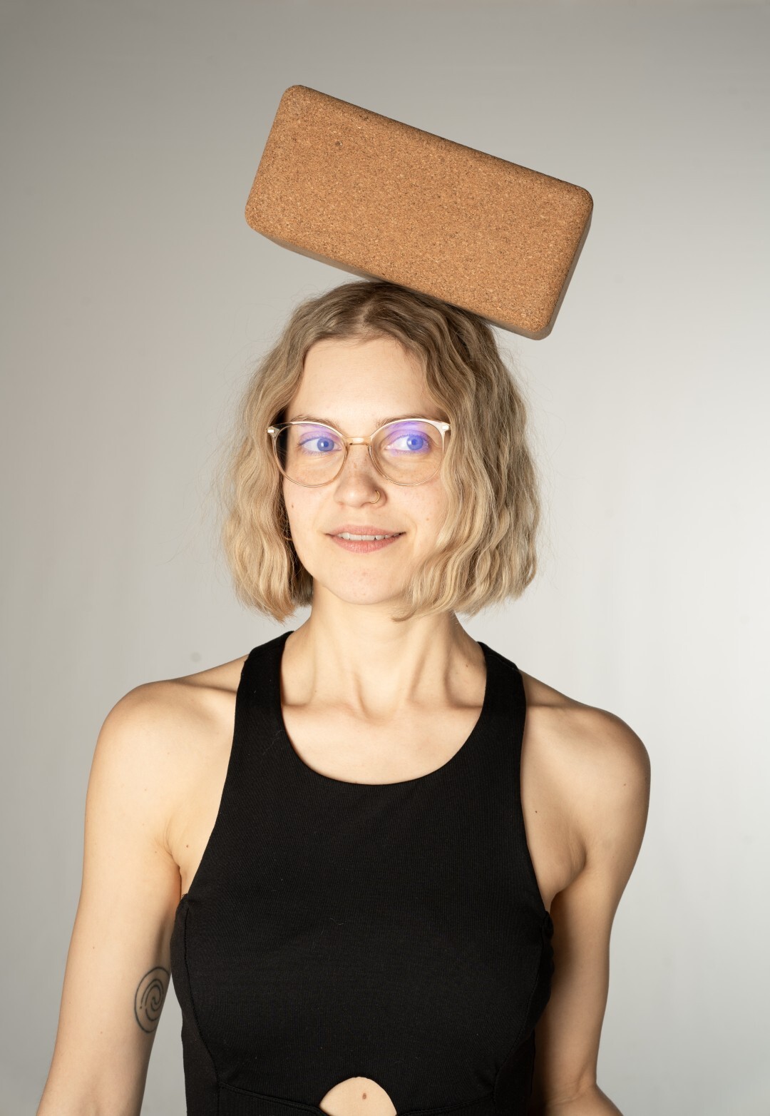 Yogalehrerin balanciert einen Yogablock auf ihrem Kopf